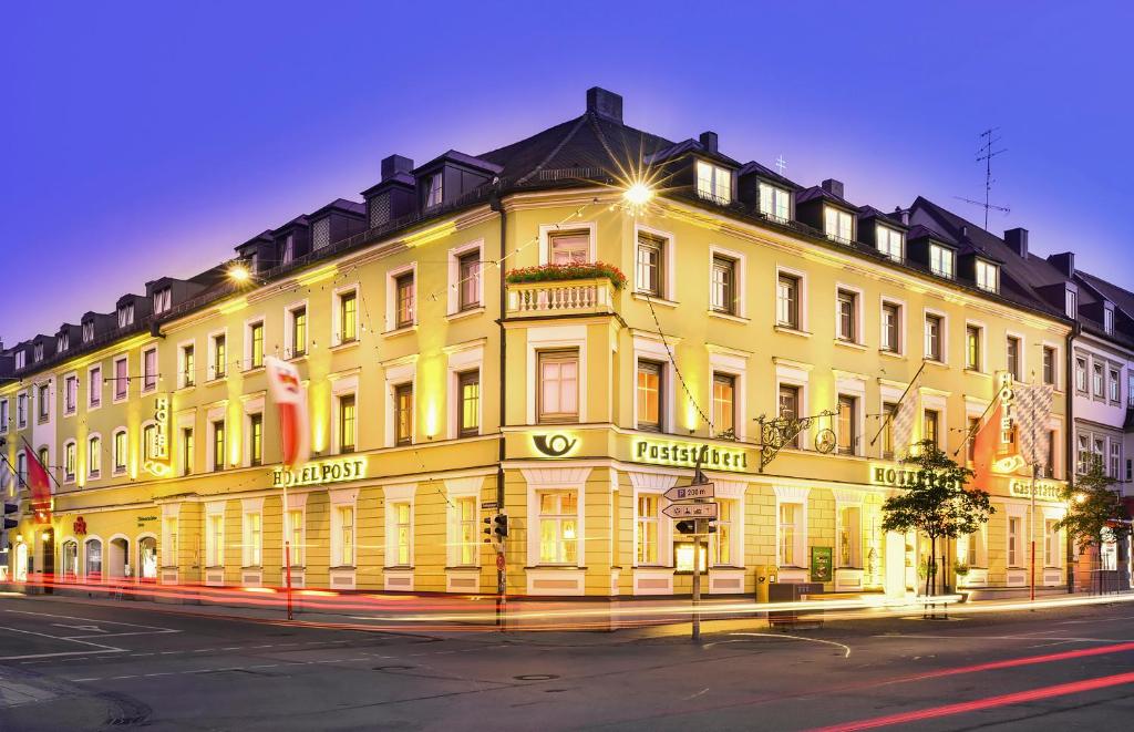 um grande edifício amarelo no lado de uma rua em Romantik Hotel zur Post em Fürstenfeldbruck