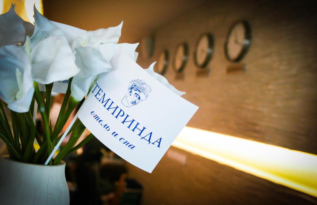 a vase of flowers with a sign on it at Temirinda Hotel in Taganrog