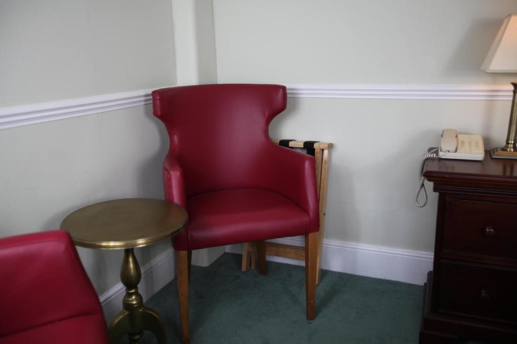 a red chair and a table in a room at Fernhill Hotel in Lyme Regis