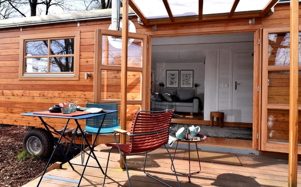 una casa pequeña con una mesa y sillas en una terraza en Tiny House Dreischwesternherz en Tréveris