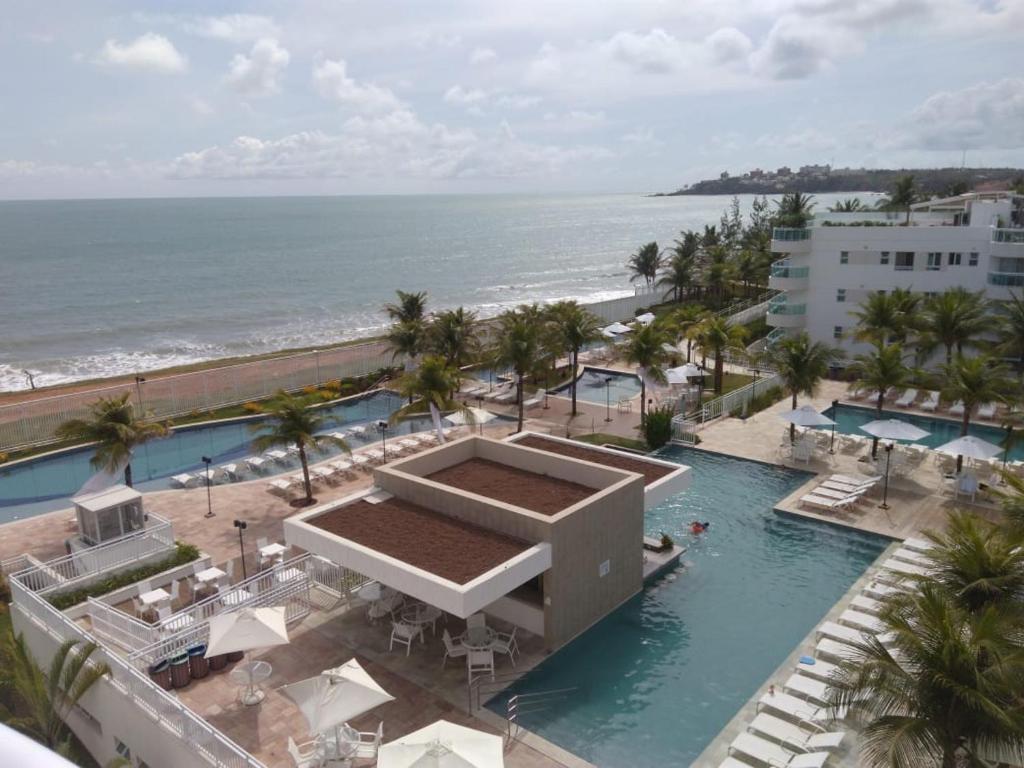 uma vista aérea de um resort com uma piscina e o oceano em In Mare Bali Resort 127 em Parnamirim