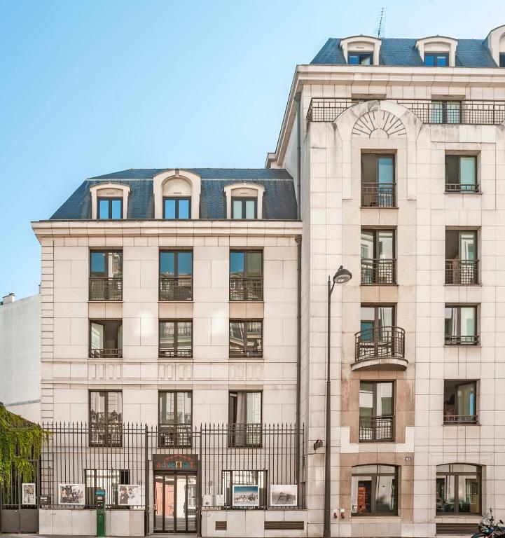 un gran edificio blanco con techo negro en Adveniat Paris, en París