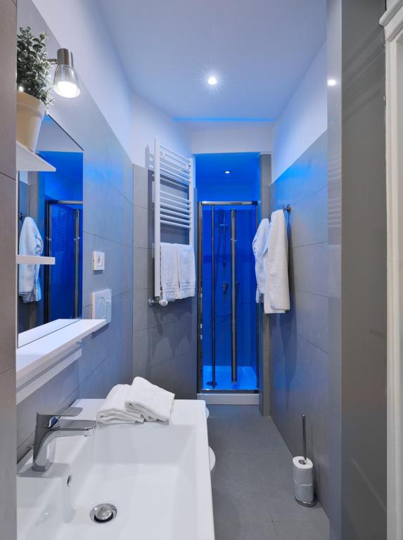 uma casa de banho com um lavatório e um chuveiro azul em Locanderia Roma em Roma