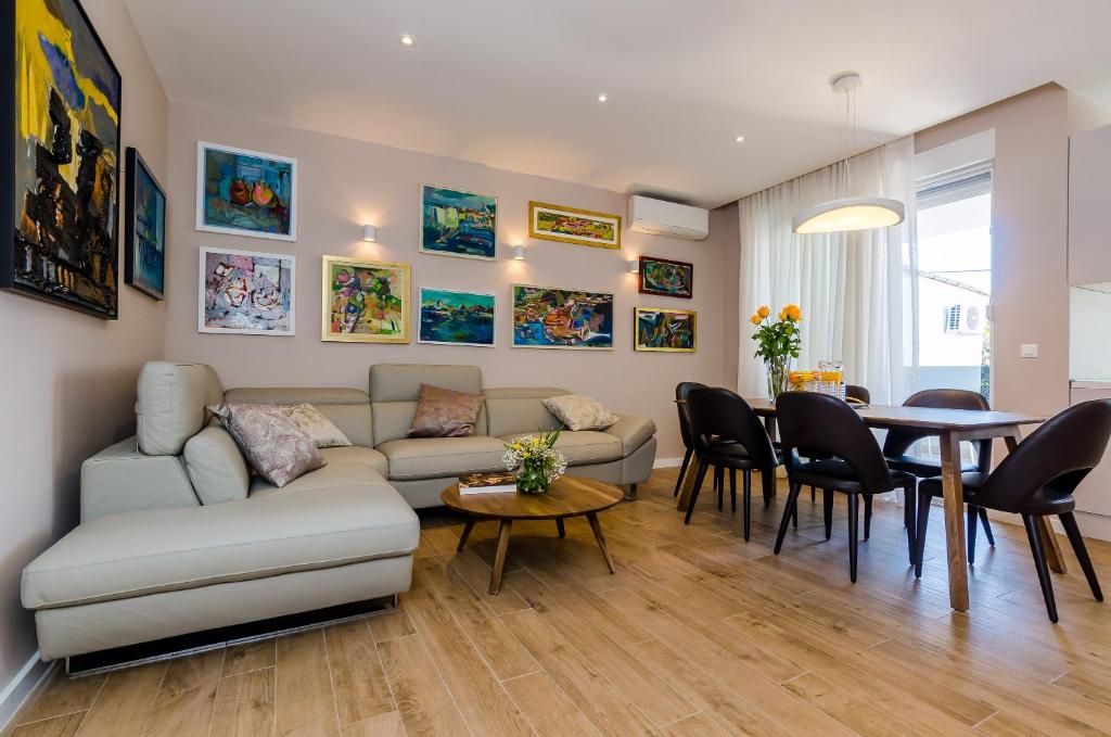 ein Wohnzimmer mit einem Sofa und einem Tisch in der Unterkunft New Art Apartment in Dubrovnik