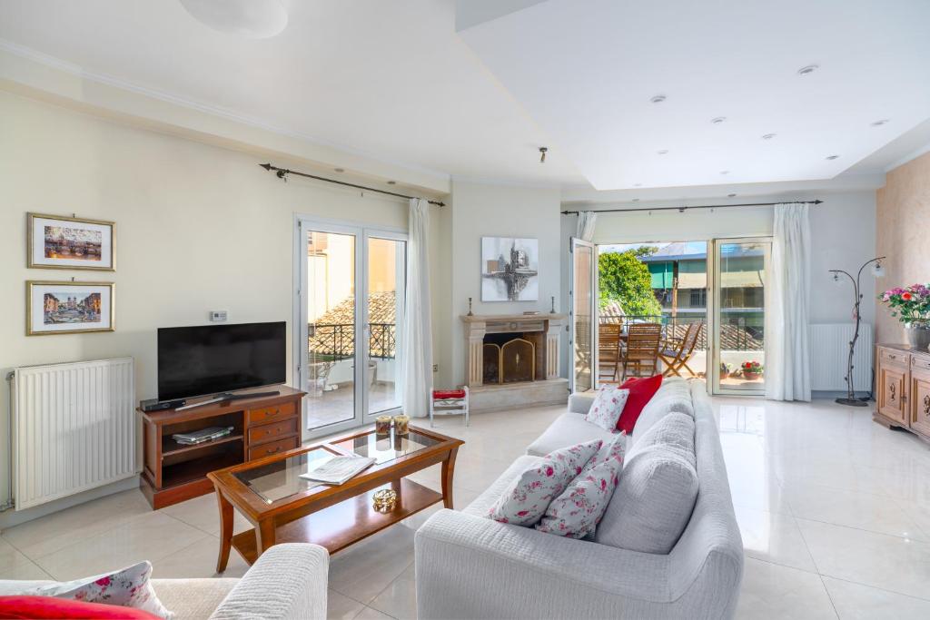 a living room with a couch and a tv at Garitsa Maisonette in Corfu