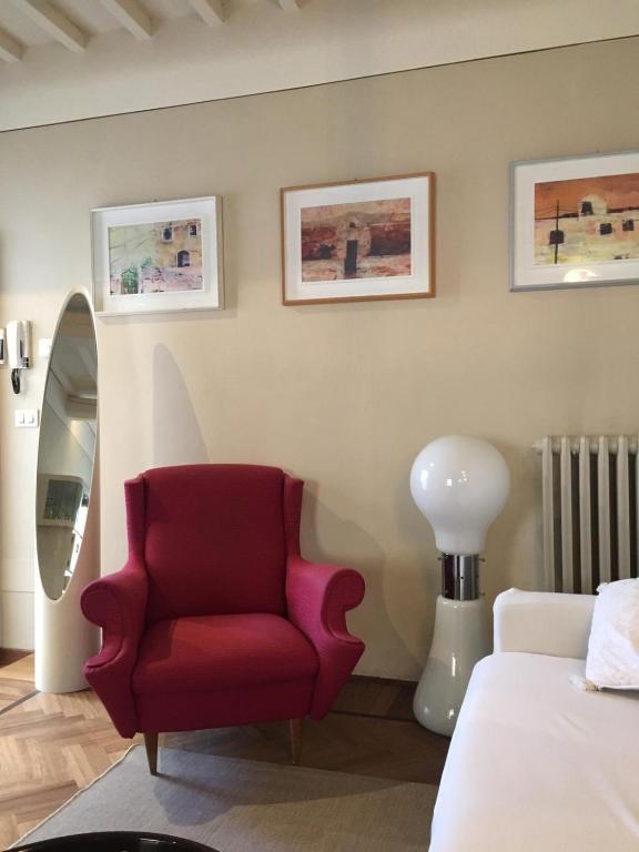 sypialnia z czerwonym krzesłem i lustrem w obiekcie Accogliente bilocale centro storico w Arezzo