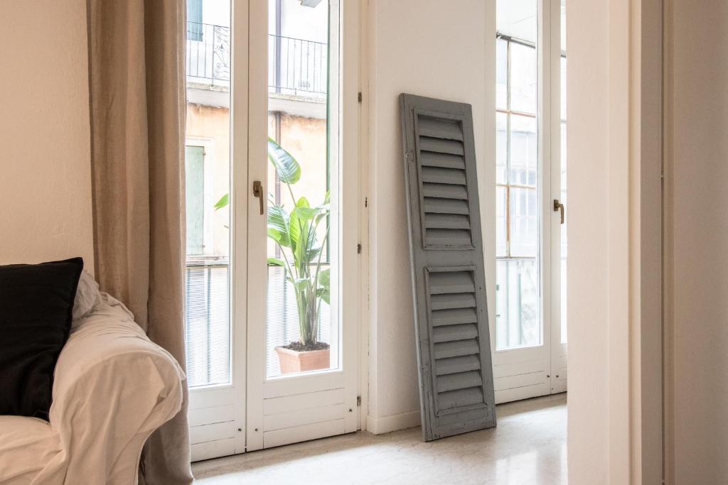 un soggiorno con porte-finestre e una pianta in una finestra di Noflik a Verona