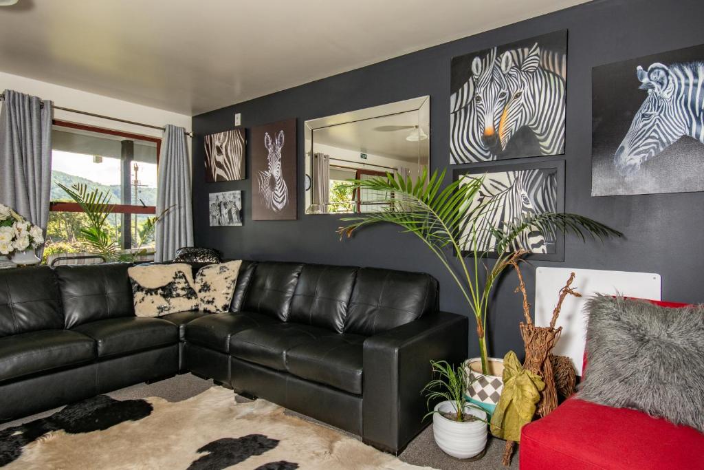 a living room with a black leather couch at Palmira Lodge in Picton