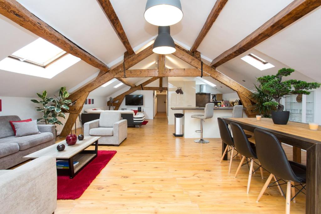 un soggiorno con soffitti in legno, tavolo e sedie. di Big loft 107m2, 10min walk to Palais des Festivals a Cannes