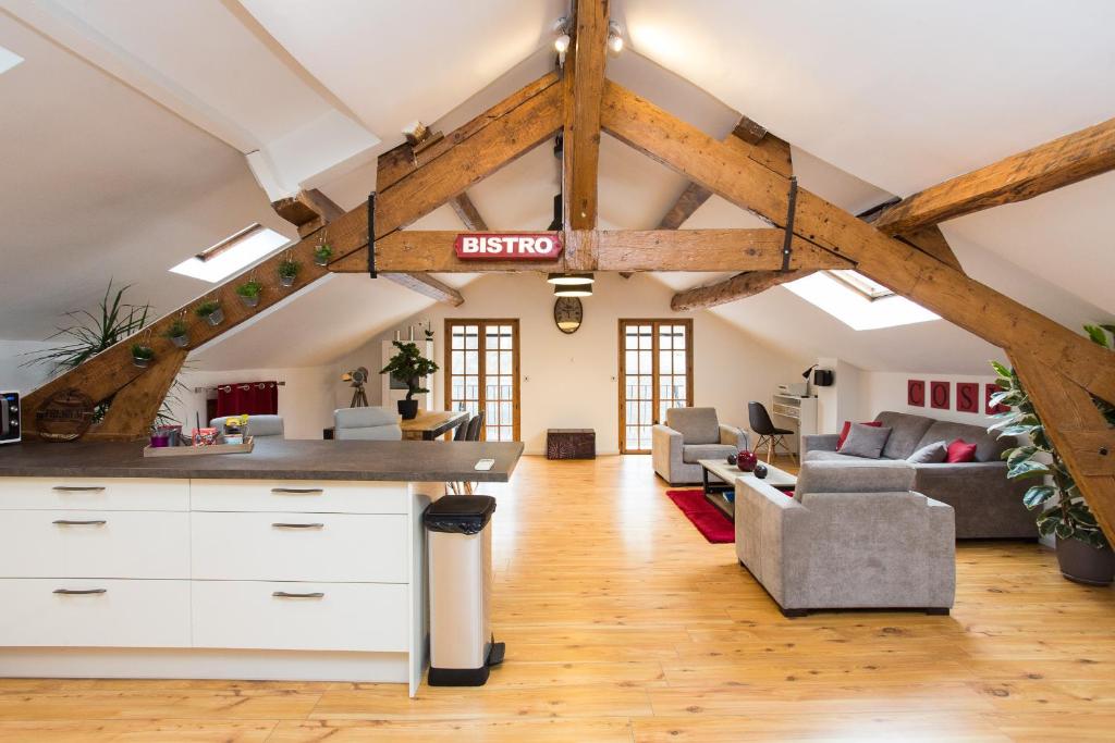 Il comprend une cuisine mansardée et un salon avec poutres apparentes. dans l'établissement LB Vacation Rentals I Big Loft 107m2, 10min Walk to Palais des Festivals, à Cannes