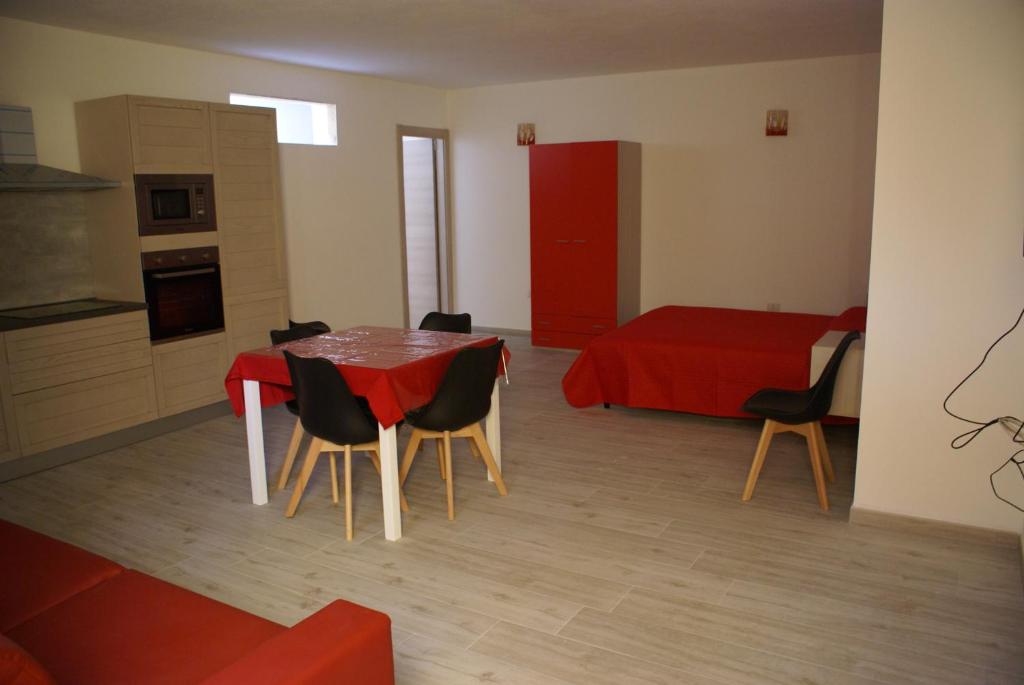 a dining room with a red table and chairs at casa mariolu 2 in Cala Gonone