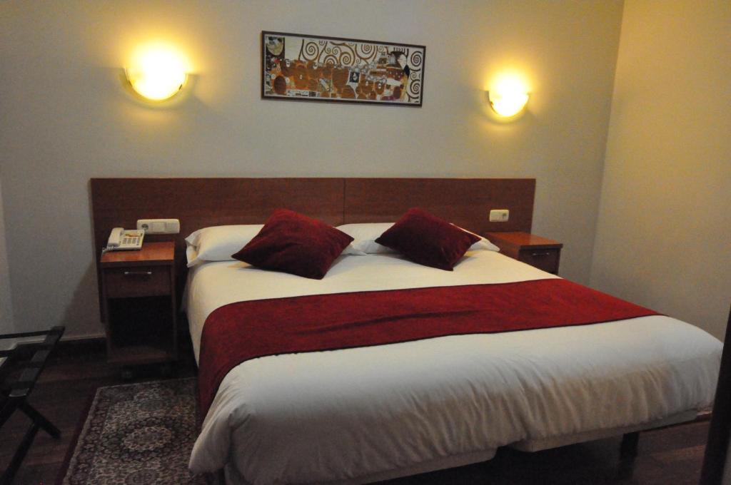 a bedroom with a large bed with two pillows at Pension Alameda in San Sebastián