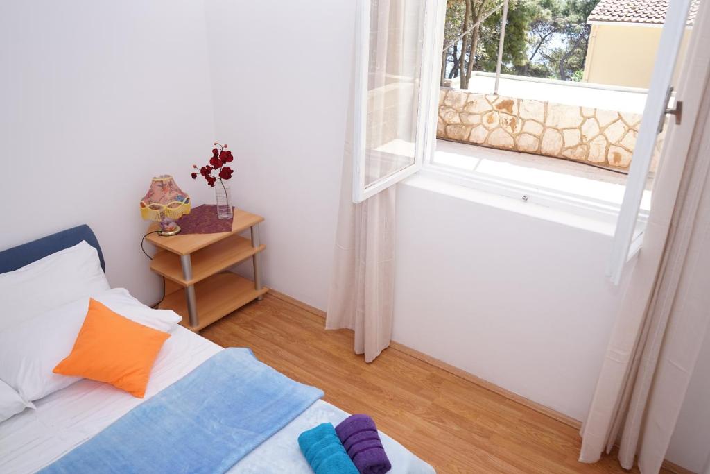 Pokój z łóżkiem i otwartym oknem w obiekcie Tania Apartment w mieście Prižba