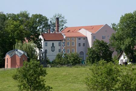 un gruppo di edifici in un campo con un'abitazione di Gutshotel Odelzhausen a Odelzhausen