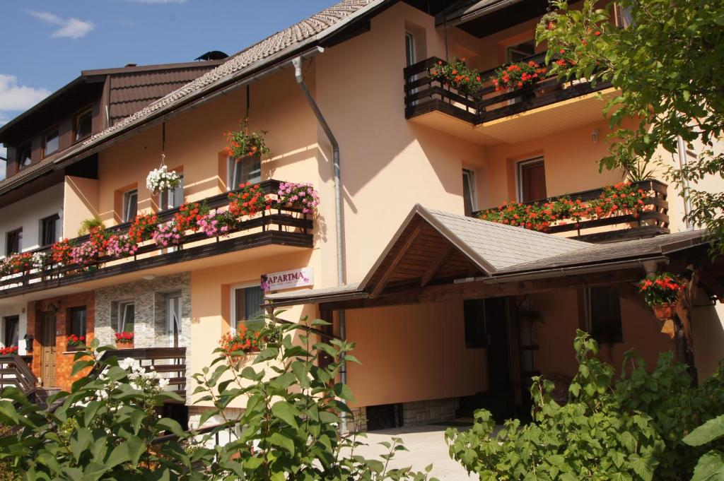 un edificio de apartamentos con macetas en los balcones en Apartments Mencinger en Bohinj