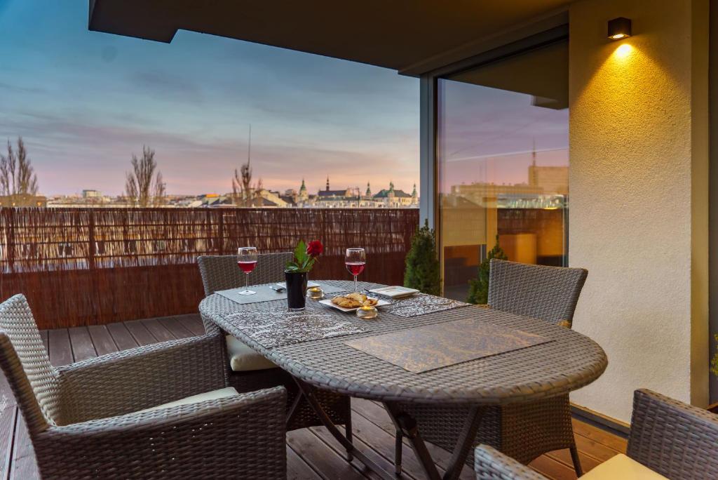 un tavolo su un balcone con bicchieri di vino di Apartament z tarasem a Kielce