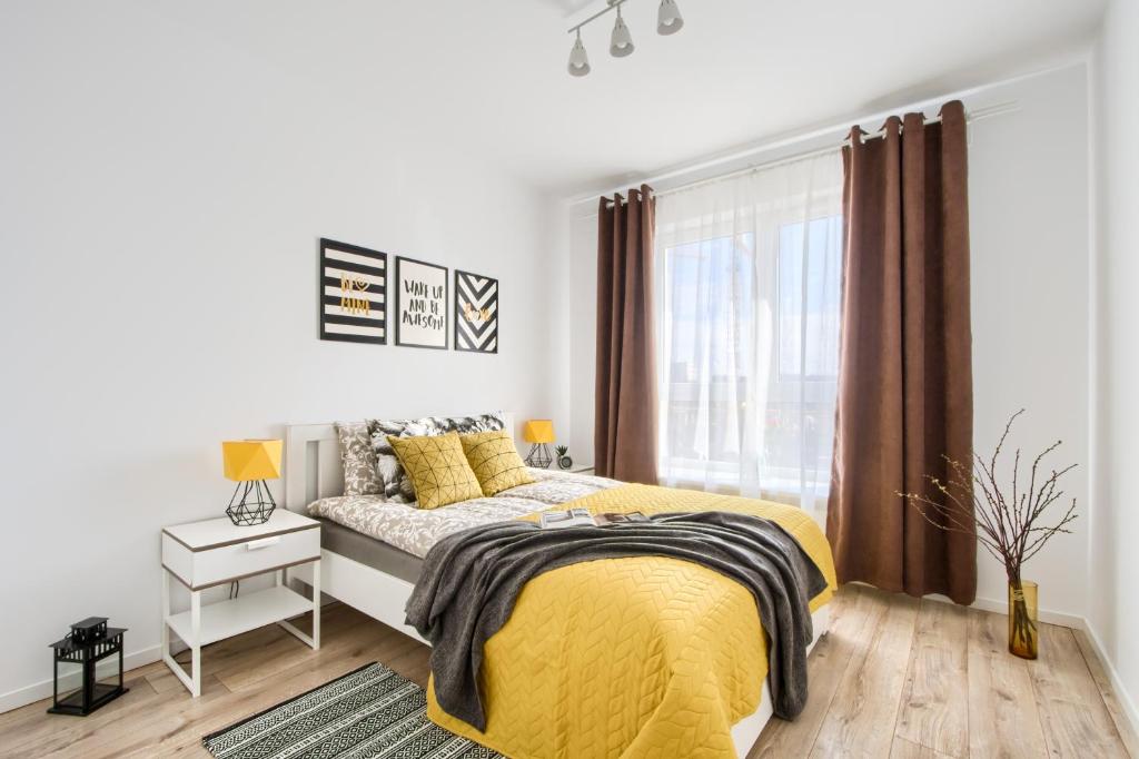sypialnia z żółtym łóżkiem i oknem w obiekcie M&R Apartament Airport&Business Premium Komputerowa - underground garage - free WiFi - Netflix - self check-in - 5 min from Chopin Airport w Warszawie