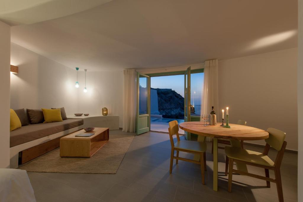 un soggiorno con un tavolo e un divano di Avatar Suites ad Akrotírion