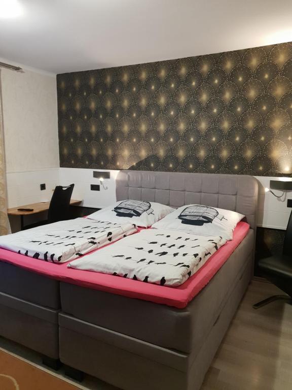 um quarto com uma cama grande e uma cabeceira preta em Waldhotel Lemberg em Hagen