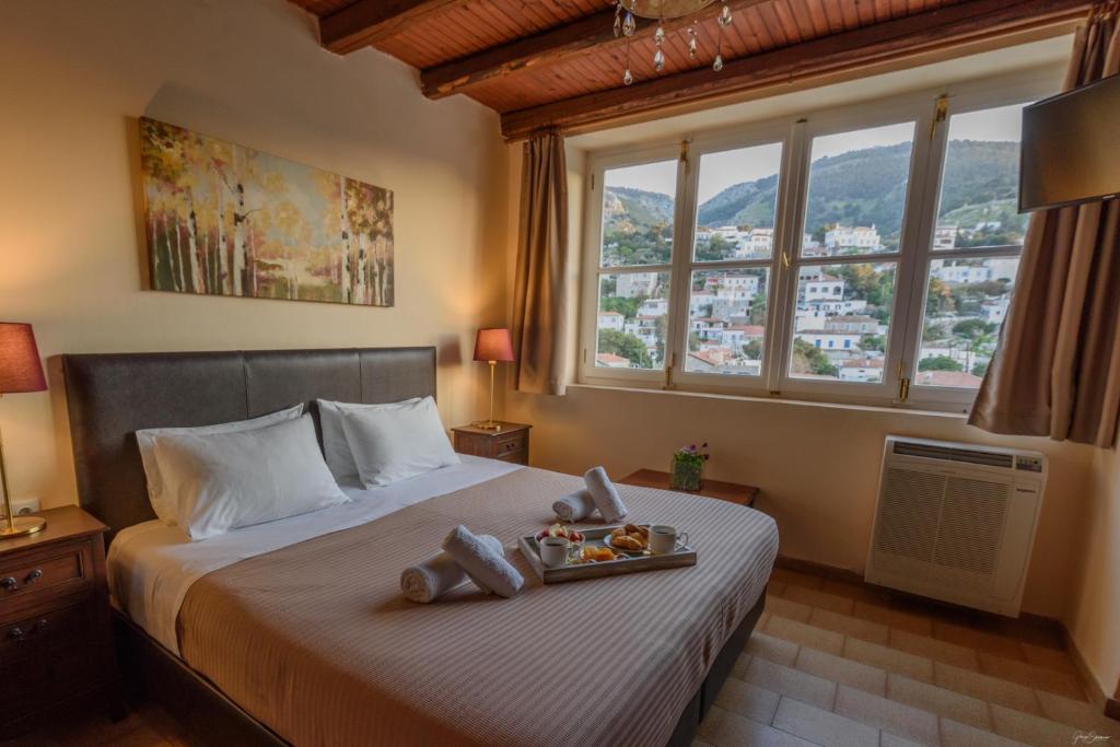 Un dormitorio con una cama con una bandeja de comida. en Athina Guesthouse en Hydra