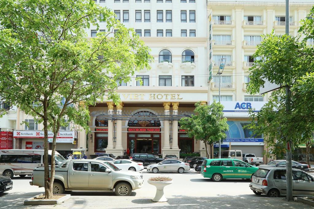 a street with cars parked in front of a hotel at Dai Viet Hotel in Thanh Hóa