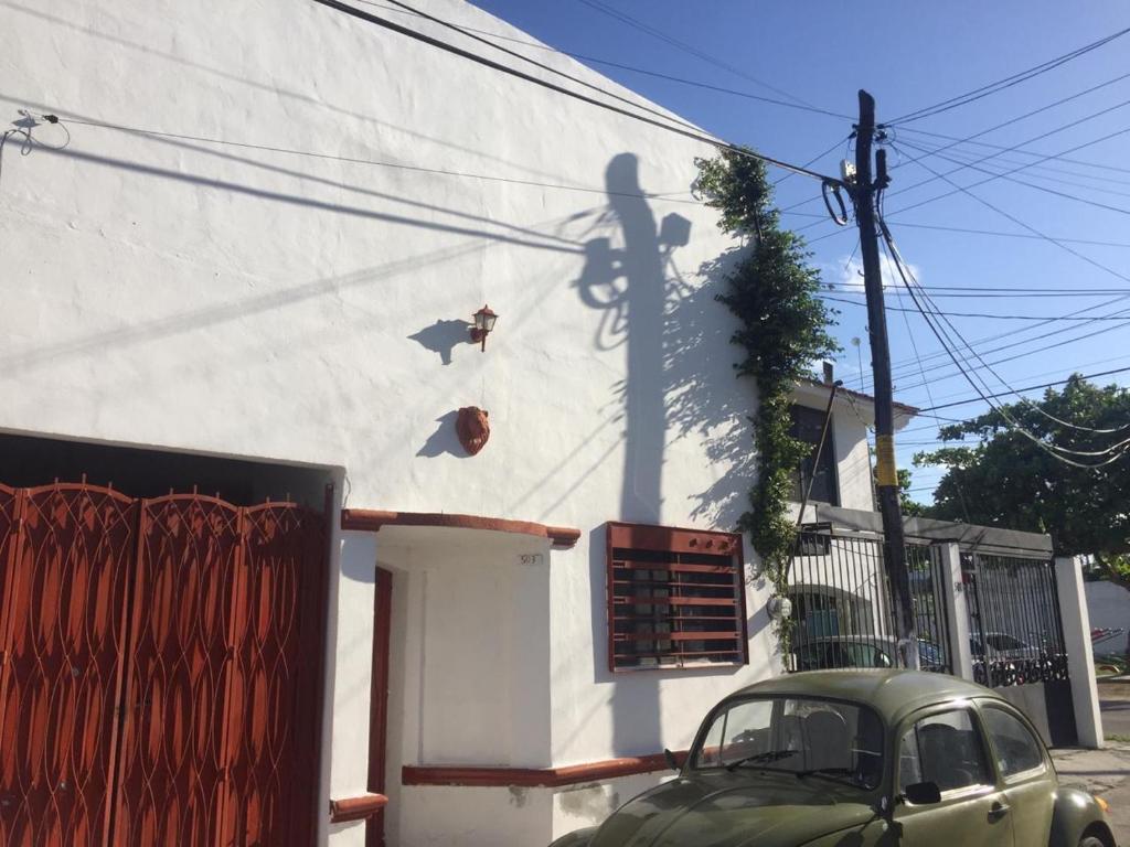 an old car parked in front of a white building at 777 LENDERMAN BnB 777 in Cancún