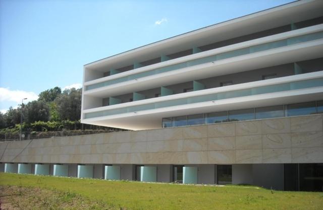 ein großes Gebäude mit einem Grasfeld davor in der Unterkunft INLIMA Hotel & Spa in Ponte de Lima