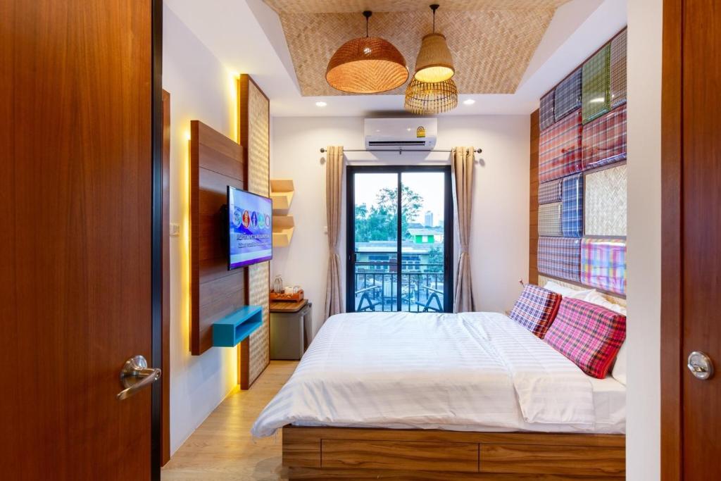 Säng eller sängar i ett rum på Lilliput Riverside Bangkachao