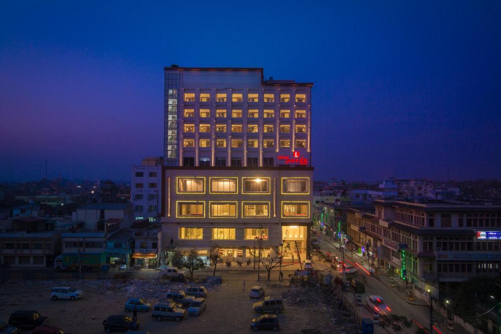 a tall building at night with cars parked in a parking lot at Diyalo Lords Plaza Birgunj in Bīrganj