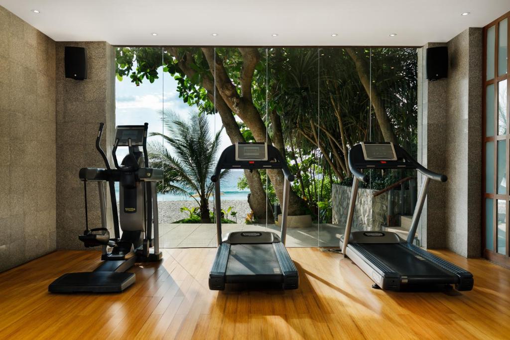 a gym with treadmills and a view of the ocean at The Surin Phuket in Surin Beach