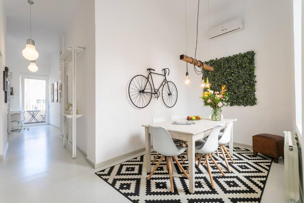 a dining room with a white table and a bike on the wall at White Loft Alicante in Alicante