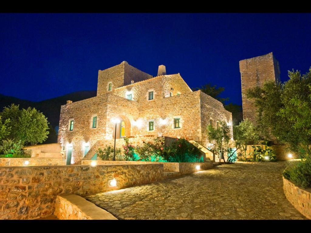 a large stone building with lights at night at Pandora in Pirgos Dhirou