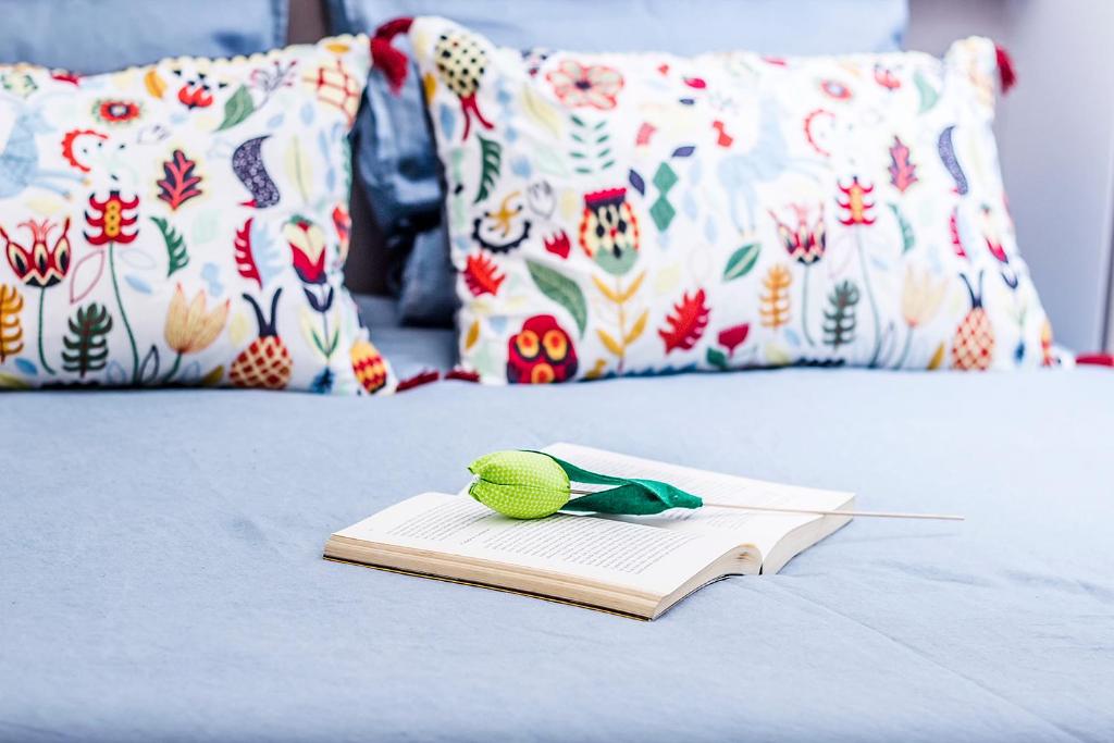 ein Buch mit einem Spielzeug auf dem Bett in der Unterkunft Enjoy Aveiro Apartment in Aveiro