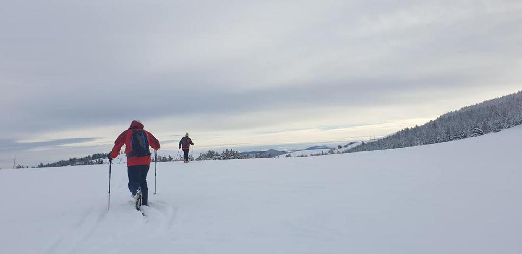 two people cross country skiing in the snow at Planinarski dom "Tornik" Zlatibor in Ribnica