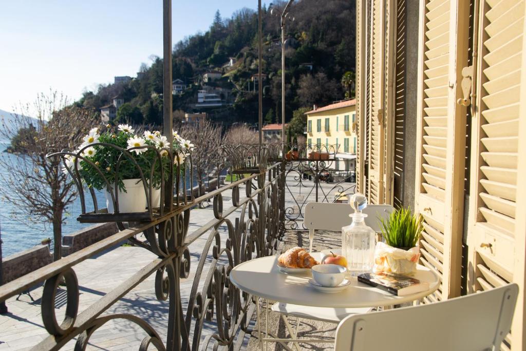 einen Tisch und Stühle auf einem Balkon mit Meerblick in der Unterkunft Casa Stoppani - WelcHome in Cannobio