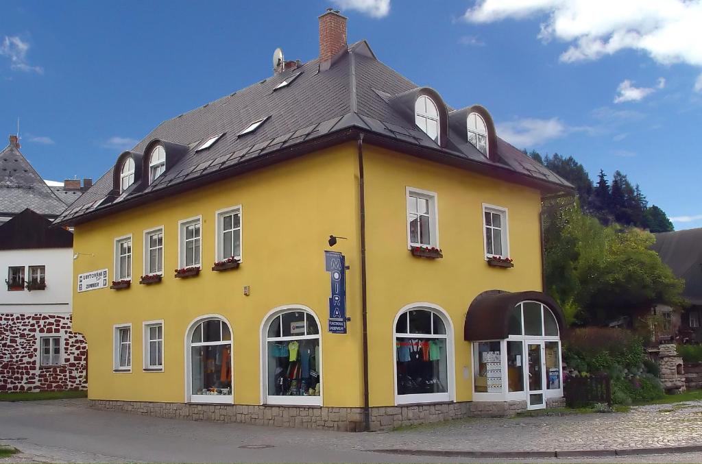 um edifício amarelo com um telhado preto em Pension Kobr em Vrchlabí