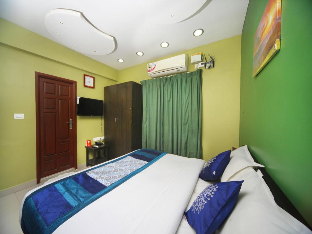 1 dormitorio con 1 cama con paredes azules y verdes en Max Classic Serviced Apartment en Chennai