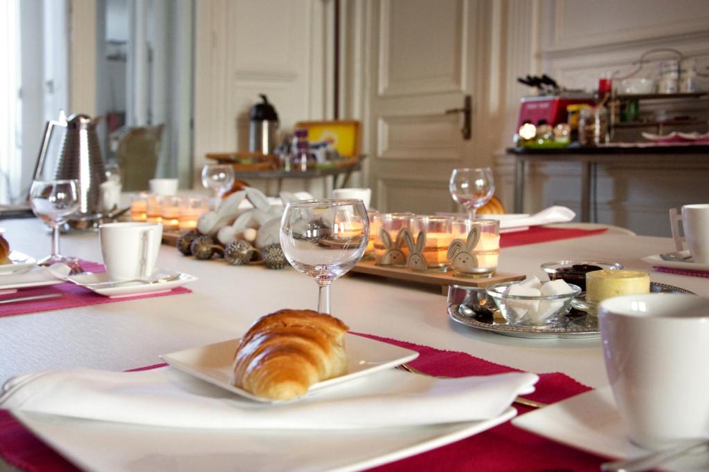 a table with a plate of bread and wine glasses at Guesthouse PPP in Ghent