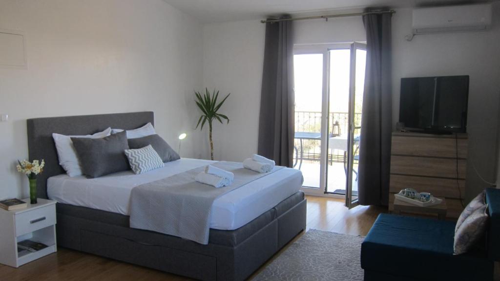 a bedroom with a large bed and a television at Ogreca in Skradin