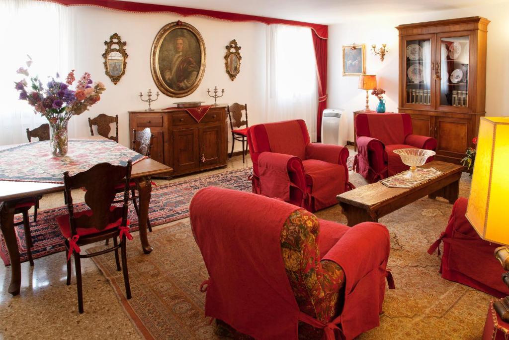 sala de estar con sillas rojas y mesa en Bell'appartamento nel cuore di Venezia en Venecia