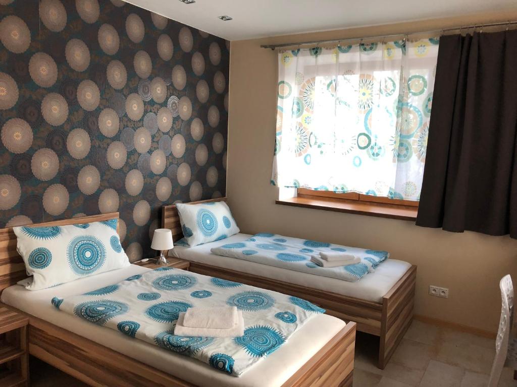 1 dormitorio con 2 camas individuales y ventana en Hotel Harmonia en Partizánska ľupča