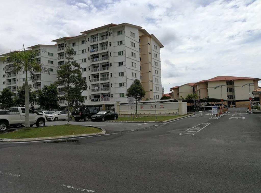 un aparcamiento frente a un gran edificio de apartamentos en Izzanial Homestay, en Sandakan