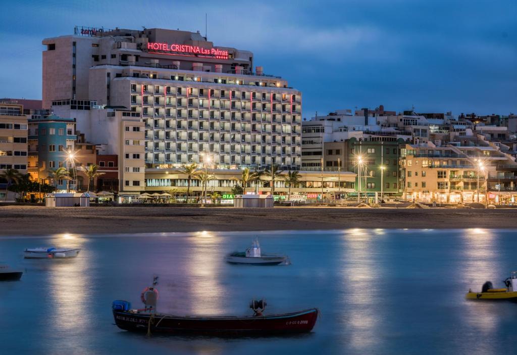 a hotel and boats in the water in front of a city at Hotel Cristina by Tigotan Las Palmas - Adults Only in Las Palmas de Gran Canaria