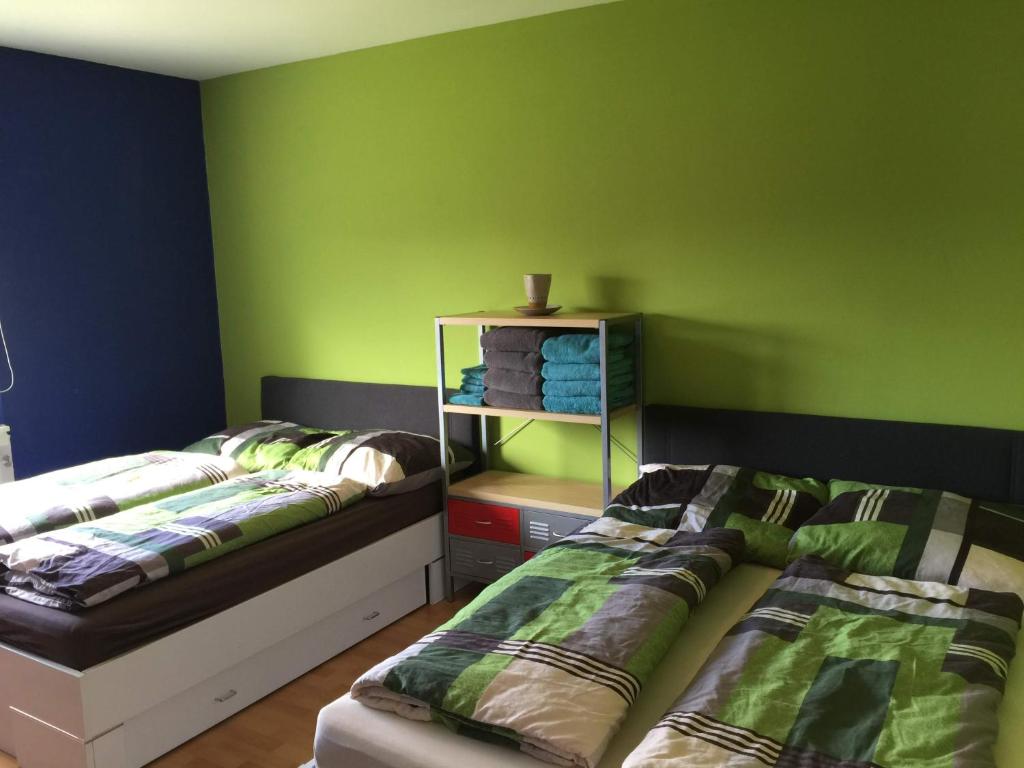 2 Betten in einem Zimmer mit grünen Wänden in der Unterkunft Ferienwohnung Viers in Bregenz