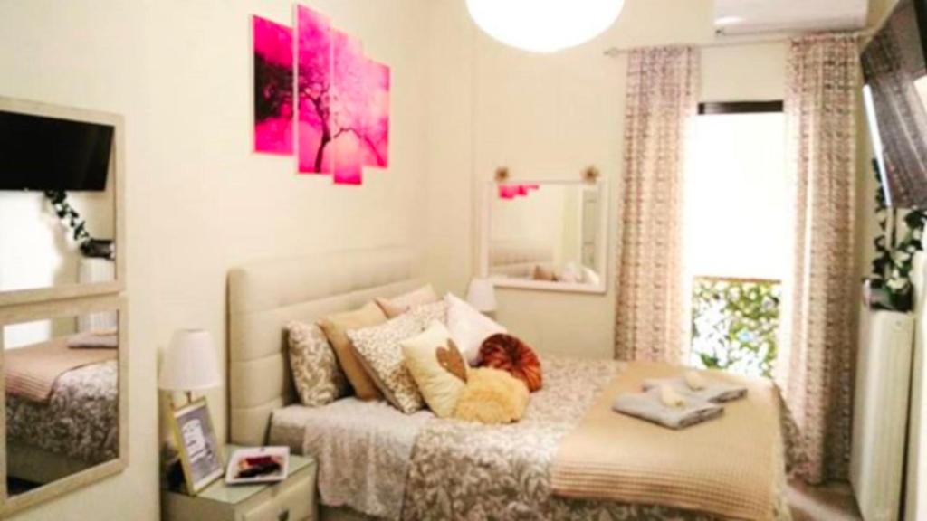Un dormitorio con una cama y una ventana grande. en Theano's Cozy & Quiet Lux Central Flat - Wifi & full Amenities, en Patra