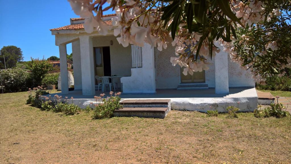una piccola casa bianca con portico e scale di Villa Singola a Valledoria