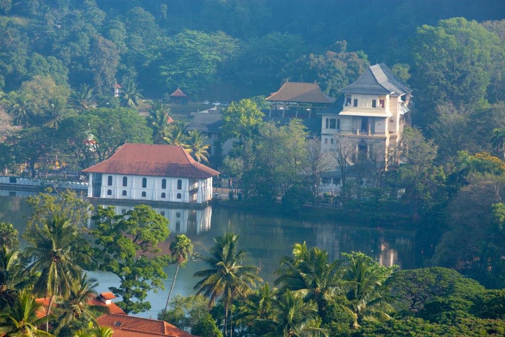un grupo de casas en una colina junto a un lago en Mcleod-Inn en Kandy