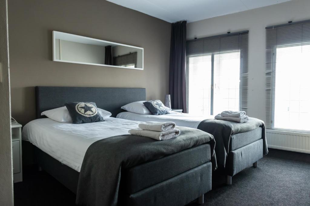 1 dormitorio con 2 camas y espejo en la pared en Hotel en Grand Café De Pauw, en Roermond