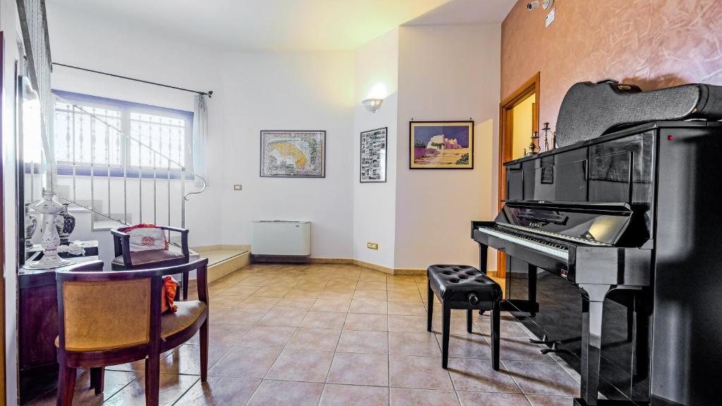 a living room with a piano and a table at Casa Del Sole Relax Room in Castrignano del Capo