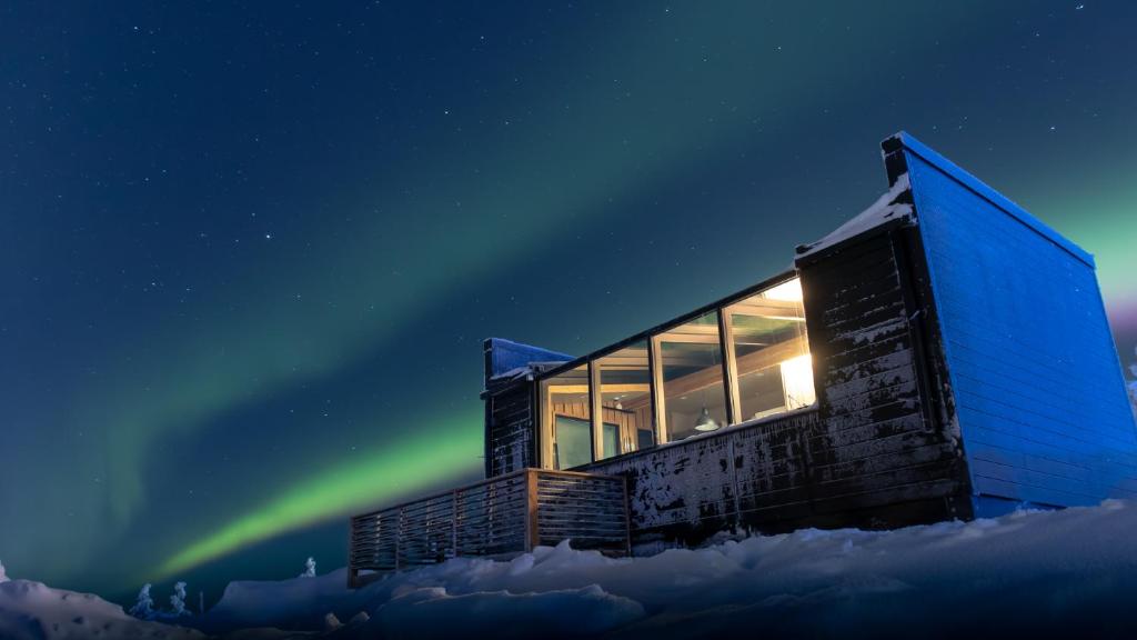 un edificio con la aurora en el cielo en Top Star Saariselkä - Arctic Glass Cubes en Saariselka